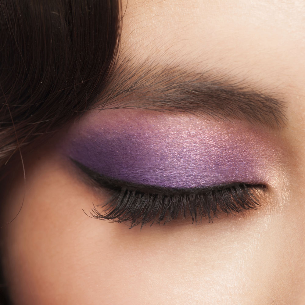 Maquillaje para mujer con sombra de ojos violeta oscuro